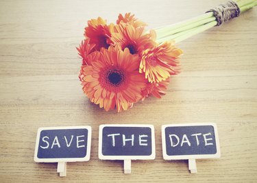 Save the date written on blackboard with flower