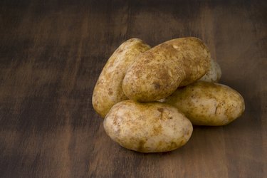 Raw Potatoes on Dark Wood Table