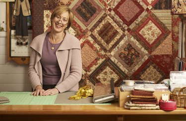 Portrait of mature woman standing behind counter in textile shop