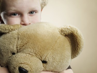 Portrait of a 6 year old boy hugging teddy bear