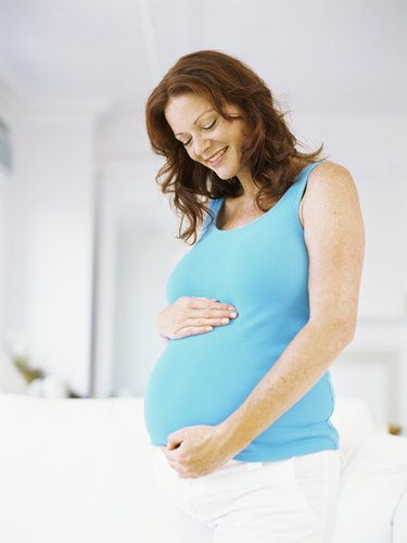 pregnant woman touching her abdomen