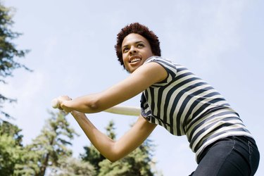 Woman batting baseball