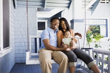 Smiling family seated on porch swing