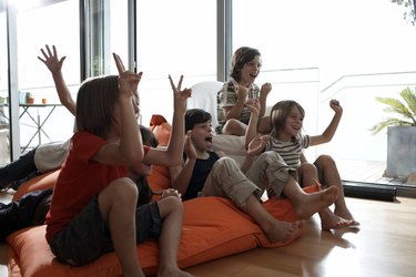 group of boys cheering in front of a television