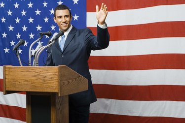 Political candidate at podium by American flag