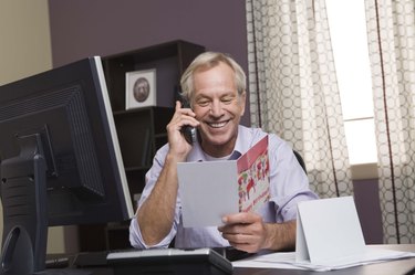 Man on the phone reading a card