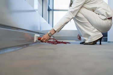 Woman plugging cord in outlet