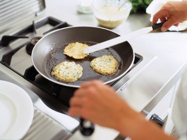 Person roasting potato fritter