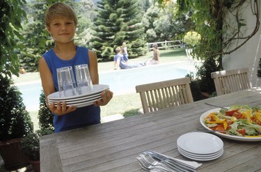 Boy carrying dishes to table