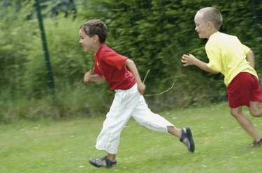 Side profile of two boys running in a park