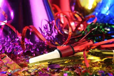 Close-up still life of New Year's Eve party favors including hats and noise makers.