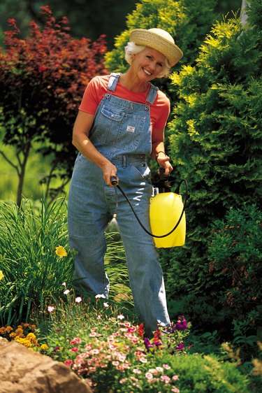 Woman with spray can in garden