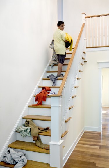 Boy dropping laundry while carrying it upstairs