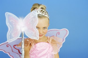 portrait of a girl wearing a fairy costume and holding a magic wand