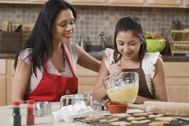 Mother and daughter baking in kitchen