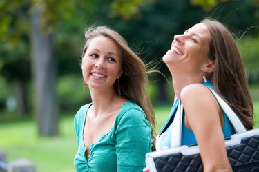 Two smiling teenage girls outdoors at park