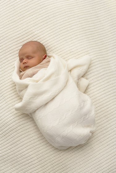 Baby boy (0-3 months) wrapped in blanket, sleeping