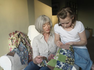 Grandmother and granddaughter (9-11) sewing quilt