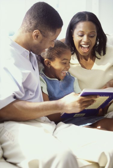 Parents reading a book with their daughter