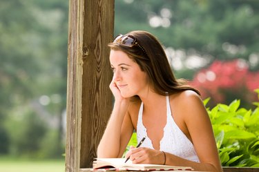 Woman writing in diary outdoors