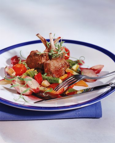 Roasted meat with vegetables on plate, close-up