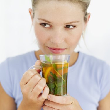 close-up of a young woman holding a cup of herbal tea