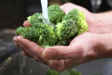 Man's Hands Washing Broccoli Vegetables in Kitchen Sink