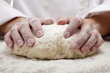 hands kneading bread dough