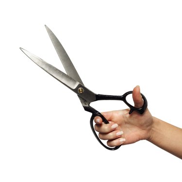 Close-up of man's hand holding scissors