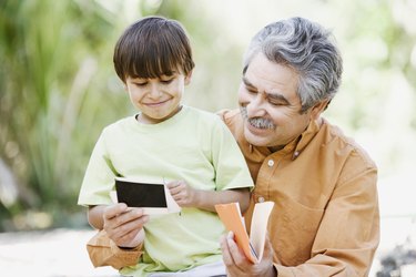 Father and son looking at photographs outdoors