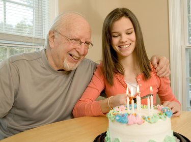 Grandfather and granddaughter with birthday cake