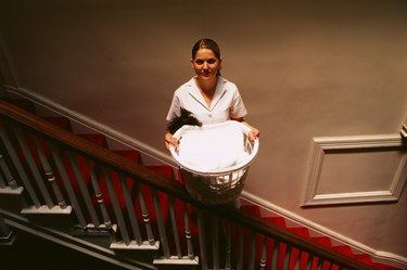 Man standing on staircase with laundry basket