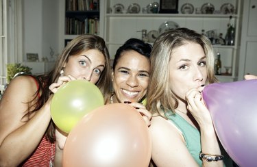 Three friends posing with balloons