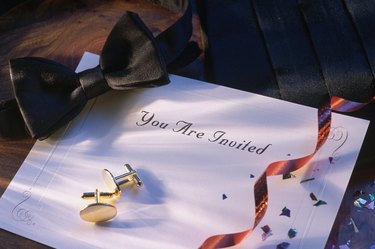 Bowtie and cuff links on top of invitation