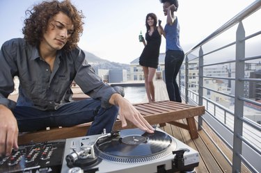 Disc jockey with turntable at party