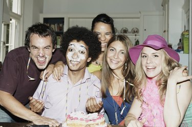 Man with icing on his face posing with friends