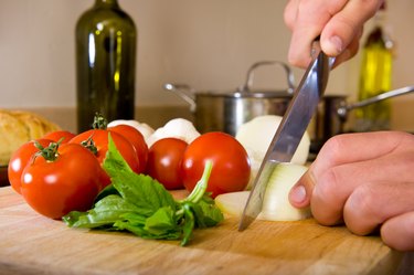 Chef's Hands Slicing an Onion