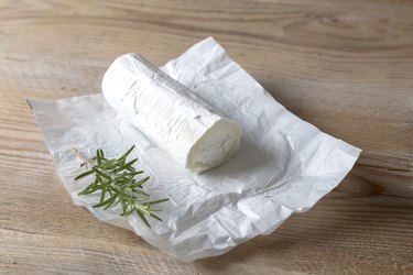 Goat cheese with rosemary on wood