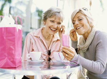 Close-up of two mature women sitting and listening to music