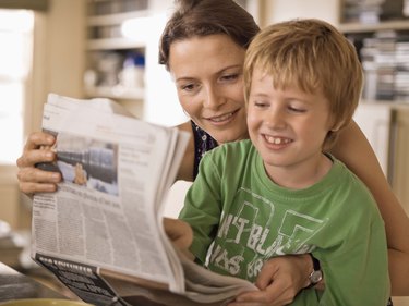 Mother and son reading newspaper together