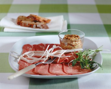 Ham with arugula leaf in plate, close-up