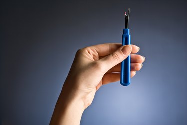 Person holding seam ripper