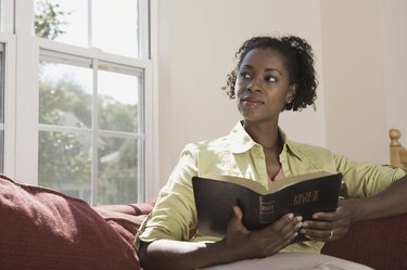 Woman holding Holy Bible indoors