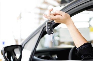 Driver woman showing new car keys