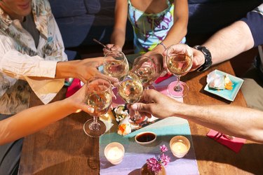 Hands toasting wine glasses