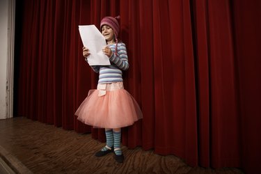 Girl (5-7) practicing lines on stage