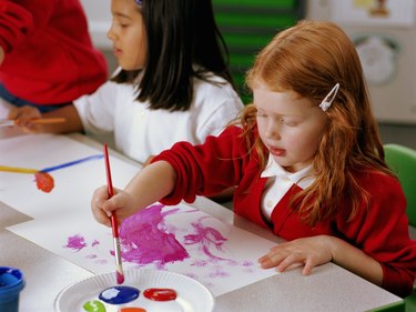 School children (4-6) painting at table, elevated view