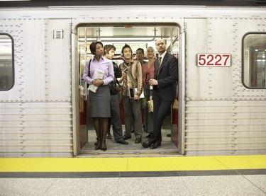 Medium group of people standing in subway train doorway