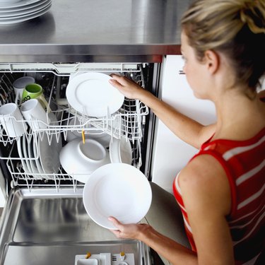 woman taking dishes out of a dishwasher