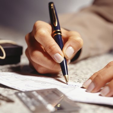 Woman signing receipt in office, (Close-up)